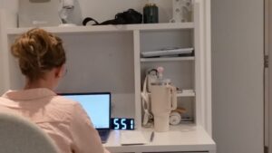 A Person Working at A Desk with A Laptop, Managing Tasks Amidst a Demanding Job