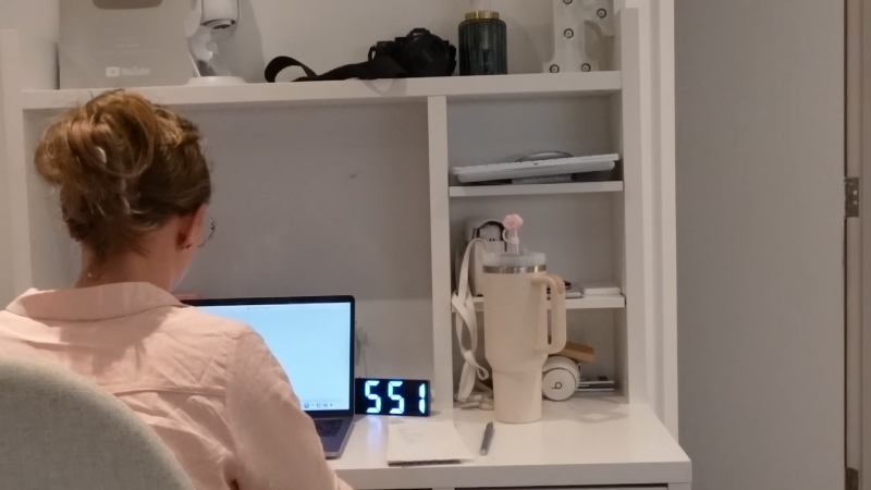 A Person Working at A Desk with A Laptop, Managing Tasks Amidst a Demanding Job