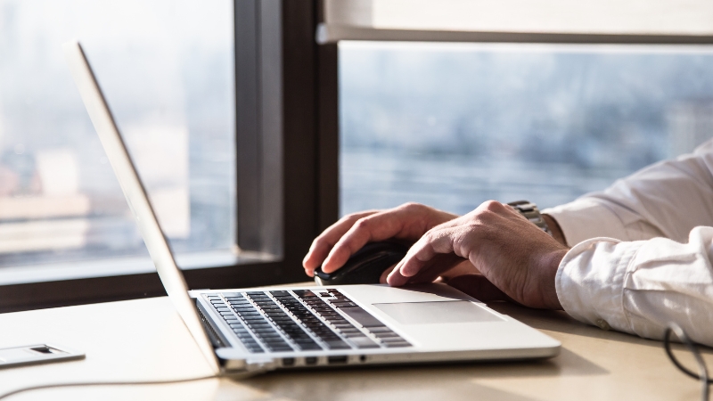 Person working on a laptop at a desk, planning creative touchpoints to impress clients