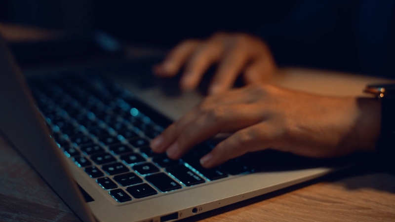Hands typing on a laptop keyboard during focused computer work