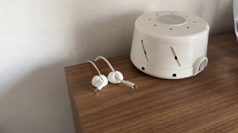 A small cord-hiding kit and cable clips keep charging cables tidy on a wooden nightstand