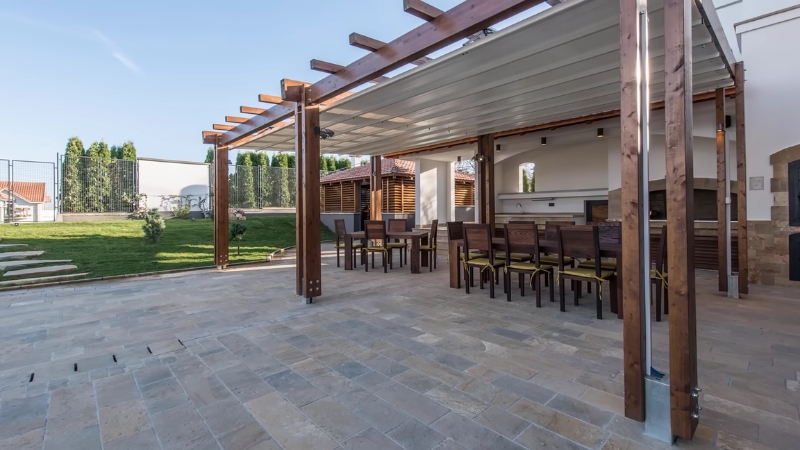 Wood pergola covering an outdoor dining area in a modern backyard patio