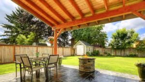 Backyard patio with wood pergola, privacy fence, and open lawn seating area