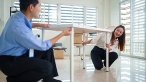 Corporate office renovation with employees setting up desks in a bright modern workspace.