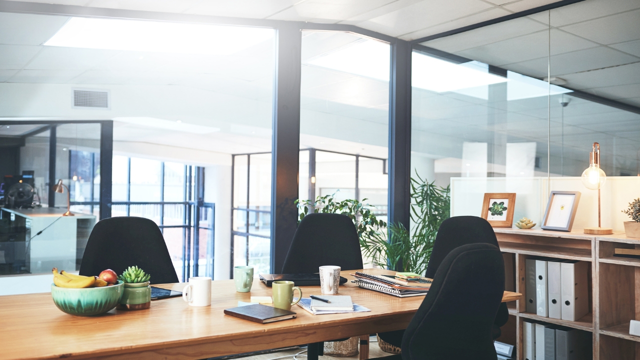 A bright office meeting area with ergonomic chairs, glass walls, and natural light