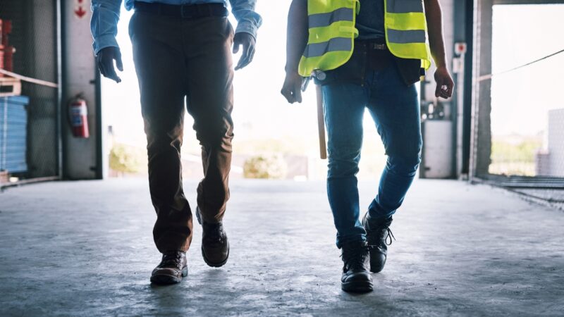 Two inspectors walk through a construction site during a compliance review