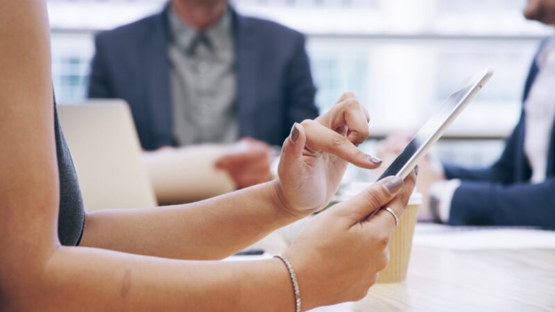 Persona usando una tablet durante una reunión de estrategia digital en una oficina
