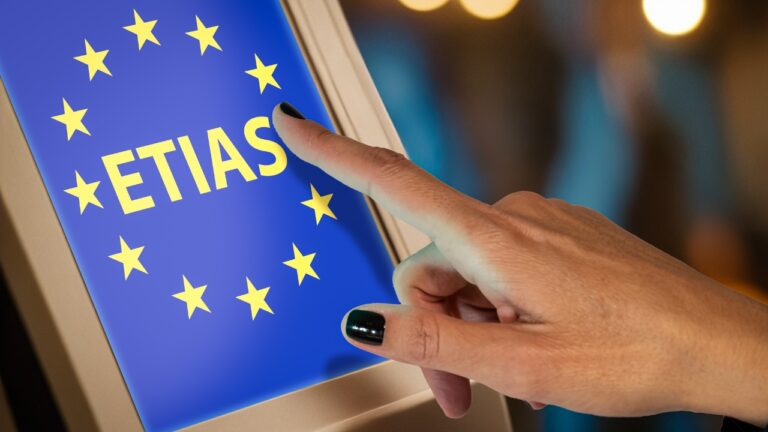 Finger taps an ETIAS screen for EU travel authorization