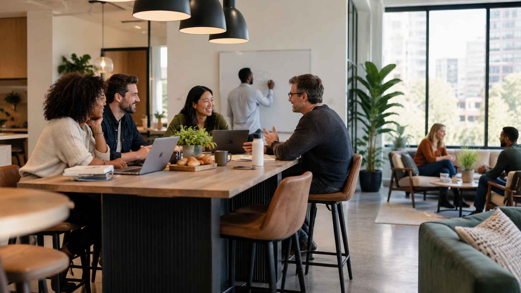 Coworkers collaborating and socializing in a modern shared office hub.